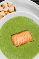 Delicious green broccoli cream-soup with salmon photo