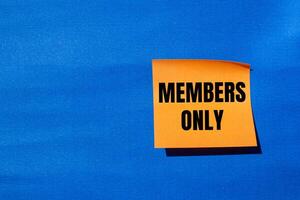 Members only message written on orange paper with blue background. Conceptual members only symbol. Copy space. photo