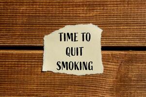 Time to quit smoking text on a piece of paper on a wooden background photo