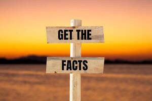 Get the facts message written on wooden sign with blurry lake background. Conceptual get the facts symbol. Copy space. photo