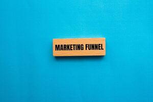 Marketing funnel message written on wooden block with blue background. Conceptual marketing funnel symbol. Copy space. photo