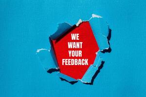 We want your feedback message written on ripped torn blue paper with red background. Conceptual we want your feedback symbol. Copy space. photo