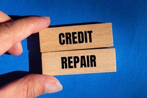 Credit repair message written on wooden blocks with blue background. Conceptual credit repair symbol. Copy space. photo