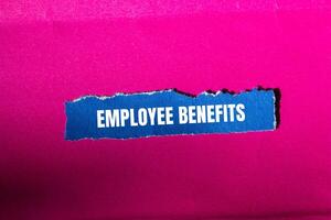 Employee benefits message written on ripped torn blue paper with pink background. Conceptual employee benefits symbol. Copy space. photo