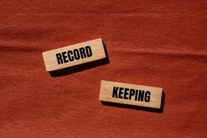 Record keeping message written on wooden blocks with brown background. Conceptual record keeping symbol. Copy space. photo