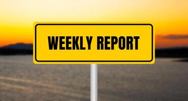 Weekly report message written on yellow sign with blurry lake background. Conceptual weekly report symbol. Copy space. photo