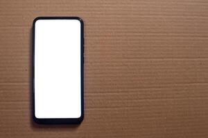 Smartphone with blank screen on cardboard background photo