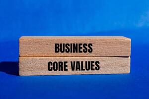 Business core values message written on wooden blocks with blue background. Conceptual business core values symbol. Copy space. photo