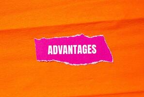 Advantages message written on ripped torn pink paper with orange background. Conceptual advantages symbol. Copy space. photo