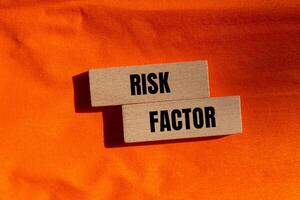 Risk factor message written on wooden blocks with orange background. Conceptual risk factor symbol. Copy space. photo