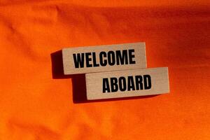 A wooden block with the words welcome aboard written on it photo