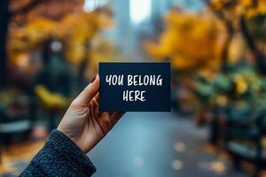 You belong here message written on black paper on autumn background. Conceptual you belong here symbol. Copy space. photo