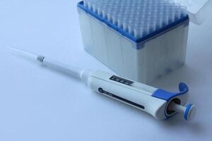 a set of plastic pipette tips in a stand. A blue tip for scientific experiments in a box. microbiological pipette for the genetic laboratory. photo