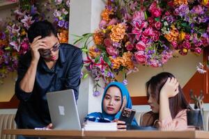 Group of workers busy thinking about company task in front of laptop computer in coffee shop cafe. for group concept, company, education, education, business photo
