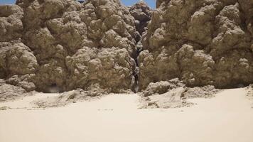 A group of large rocks sitting on top of a sandy beach video