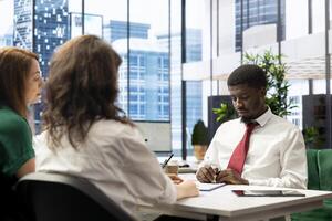 HR employees reviewing candidate resume while asking targeted questions about qualifications. Man at interview providing detailed answers, showcasing expertise and enthusiasm for job opportunity photo