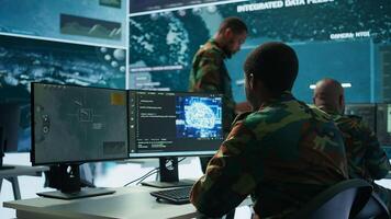 Programming engineer soldier handles AI brain and deep learning data on computer in command post, coordinates national defense operations. Neural network artificial intelligence science. Camera B. photo