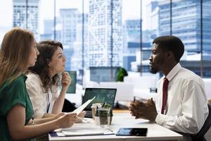 Stock market company HR professional reviewing candidate CV, asking questions about qualifications. Person getting hired by recruiter after proving skills for economic startup job photo