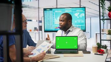 Elderly people meeting with a financial expert next to chroma key display, exploring various retirement options and ensuring their savings for the future. Investment strategy advice. Camera B. photo