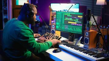 Talented musician creating new soundtracks on mixing console, operating on audio equipment in home studio. Sound technician twisting knobs to edit volume levels on his melody. Camera B. photo