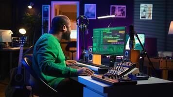Sound engineer playing piano and mixing tunes on digital software, composing new songs and adding audio effects in post production. Artist composer creating soundtracks for music industry. Camera B. photo