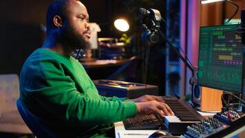 Talented artist composing new lyrics for his tracks and recording music with audio devices in his home studio. Singer composer writes melodic material by taking notes and creating rhymes or songs. Camera A. photo