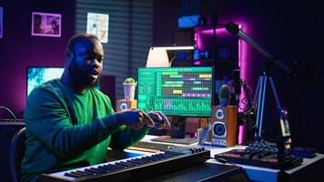 Musician doing online paid classes to help people play piano notes, teaching lessons from his home studio and recording tutorials. Musical instructor playing midi controller keyboard. Camera B. photo