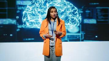 Speaker talking with audience on stage at AI conference bringing together leading experts and researchers to explore latest developments in artificial intelligence and machine learning, camera A photo
