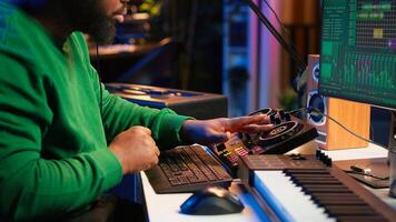 Talented musician creating new soundtracks on mixing console, operating on audio equipment in home studio. Sound technician twisting knobs to edit volume levels on his melody. Camera A. photo