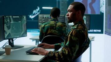 Military personnel in a high tech command center monitor satellite feeds, coordinate intelligence operations. Maintaining national security and supporting strategic army missions. Camera A. photo