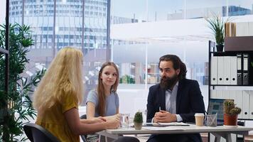 Financial advisor developing and presenting financial strategies and plans to customers. Consultant in office assisting clients with investment portfolio management, camera B photo