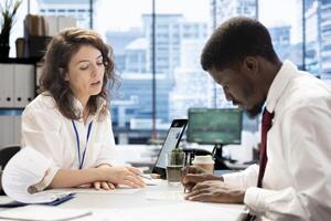 Human resources worker agreeing terms with candidate during job interview, sitting at office desk. HR employee selecting candidates to work for company, signing contract with applicant photo