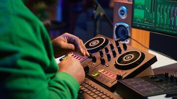 Music technician with headset mixing and mastering his audio recordings, operating on console in home studio. Musician producer creating new tunes with sound effects in post production. Camera A. photo