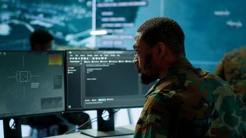 Soldier working with AI intelligence on pc in control room, processing live data on cctv systems. Surveillance efforts to support field missions and defense operations, national security. Camera A. photo