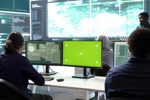 Group of professional hackers use mockup copy space screen in government operations center, high tech devices. Experts operating on big screen and surveillance for intelligence. photo