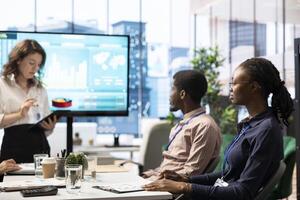 Coworkers engaging in a problem solving meeting at a corporation, using an interactive board to visualize data and develop solutions for complex business challenges. Analysis presentation. photo