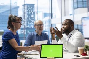 Financial expert counseling senior citizens to discuss insurance policy, having chroma key on tablet and choosing a suitable retirement plan. Mature man and woman investing life savings. photo