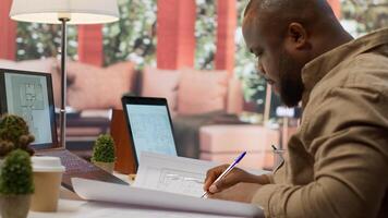 Owner of a tech startup searching for new office spaces by using blueprints to plan the construction and renovation of the corporate building. Evaluating and reviewing workplace drafts. Camera A. photo