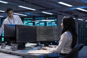 Software developer using computer, optimizing data center performance. Woman coding on PC, troubleshooting mainframes, ensuring optimal performance and minimizing downtime photo