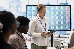 Diverse work team collaborating on project management tasks, utilizing smart technology and detailed analytics to optimize resource allocation and ensure enterprise objectives. photo