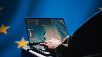 European Union using radar system on laptop to detect incoming ballistic missiles attacking member states. EU alliance army soldier scanning rockets approaching countries, deploying shields, camera B photo