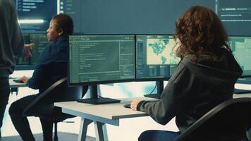 Group of governmental hackers using hacking tools to secure a network, focusing on cyber defense and data protection measures. Experts team examining important information on big screen. Camera A. photo