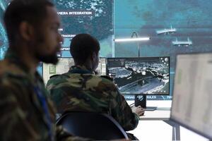 Soldiers in a state of the art military control room collaborate on data analysis, intelligence gathering, and mission planning. Their efforts ensure the effectiveness and security of military operations. photo