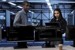 Technicians in data center using devices to check for server performance issues arising due to high CPU usage. Server farm staff members fixing insufficient memory errors slowing down hardware photo