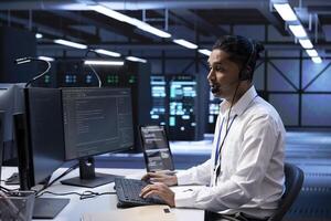 Technician in data center providing support for partnering startups, troubleshooting malfunctions. Worker in server hub call center carrying out operational interventions requested by clients photo