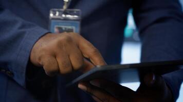 Technician in server hub checking recovery plan on tablet, monitoring energy consumption across mainframes. Close up shot of man in data center making sure rigs are functioning optimally, camera A photo