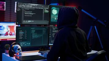 Hacker arriving in underground HQ, ready to start coding malware designed to exploit network backdoors and bypass security measures such as logins and password protections, camera B photo
