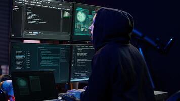 Hacker arriving in hidden underground shelter with laptop, prepared to launch malware attack on websites. Scammer in apartment starting work on dangerous script that can breach security, camera B photo