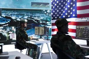US military officer supervising threat detection activity in high tech office, examining top secret data on big screen. American army soldiers managing hybrid war, cyber attack prevention. photo