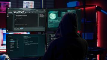 Experienced hacker writing lines of code on computer from underground bunker, tying to get past security systems. Rogue programmer building scripts that can hack devices, camera A photo